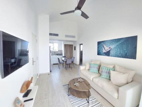 a living room with a white couch and a table at Hard Rock Golf Cozy 1BR • Pool & Golf Views in Punta Cana