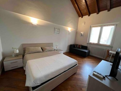 ein Schlafzimmer mit einem Bett und einem Schreibtisch mit einem Computer in der Unterkunft Villa Perosi in Vigevano