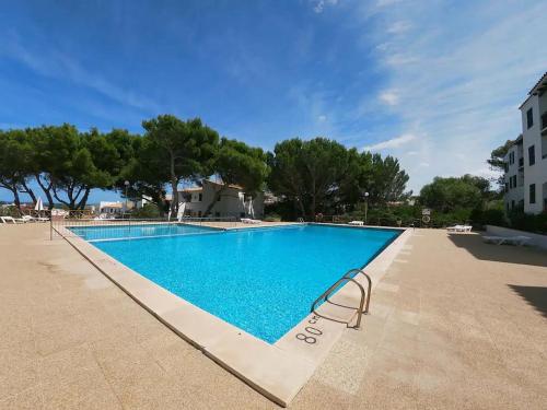 una piscina en un complejo con un azul claro en Apartamento Sol Isla Arenal de'n Castell en Arenal d'en Castell
