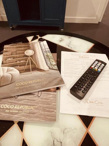 a table topped with a remote control and papers at City Hidden Gem in Melbourne