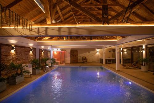 a large swimming pool in a building with a ceiling at Due Fratelli Village Resort in Şinteu