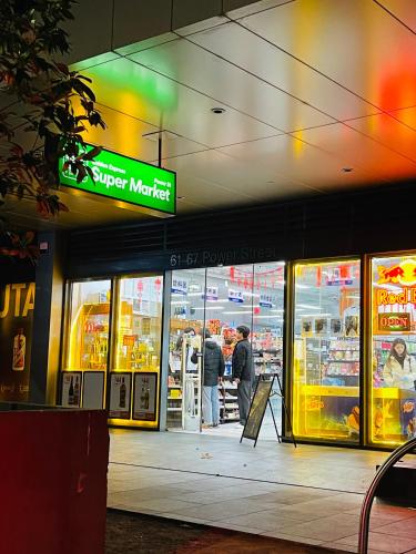 a store front of a supermarket with people standing inside at City Hidden Gem in Melbourne