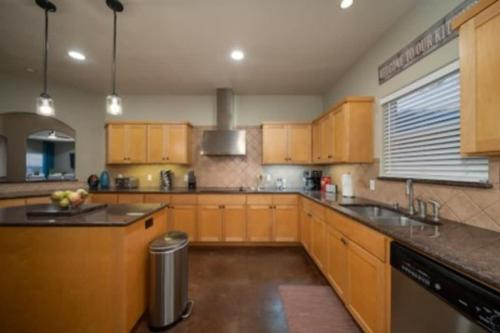a large kitchen with wooden cabinets and a sink at Brand New Lake Travis Estate - Awesome Pool in Austin