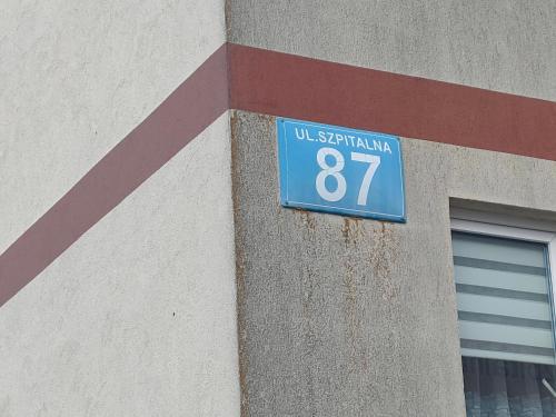 a blue street sign on the side of a building at Apartament Szpitalna in Suwałki