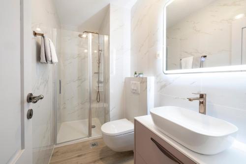a white bathroom with a sink and a shower at BRAND NEW Stone house MARCELA, 3 double bedrooms, pool in Lun