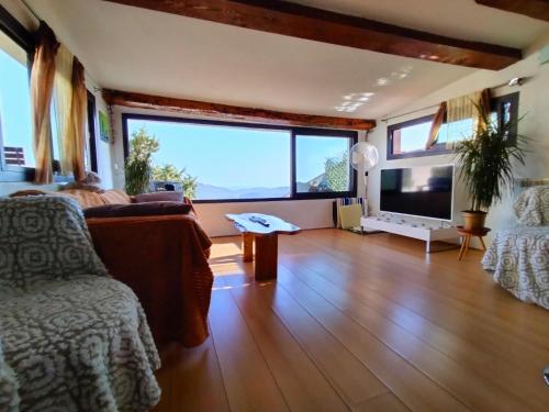 sala de estar con sofá y ventana grande en Le Castellet Vue Panoramique, en Le Castellet