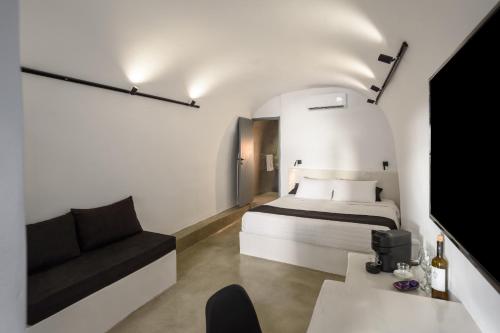 um quarto com uma cama e um sofá em Pyrgos Cave Suites em Pírgos
