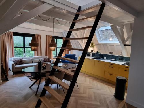 米德爾堡的住宿－Elysian Yellow Suite，厨房以及带阁楼梯子的客厅。