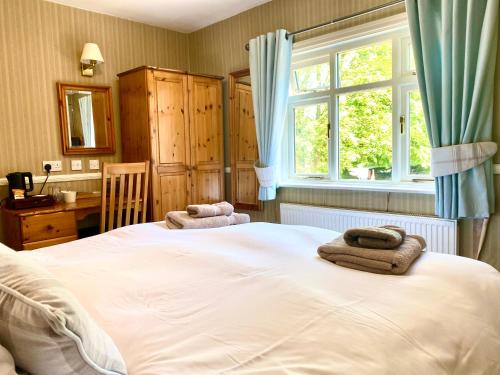 a bedroom with a large bed with towels on it at The Egerton Arms Astbury in Congleton