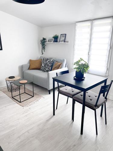 un salon avec une table et un canapé dans l'établissement Le gargantua, appartement à 500m du château, à Chinon