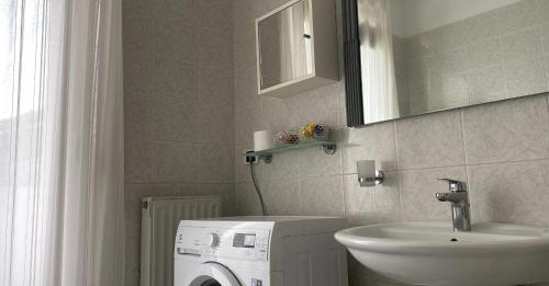 uma casa de banho com uma máquina de lavar roupa e um lavatório em Appartamenti Nataly em Nago-Torbole
