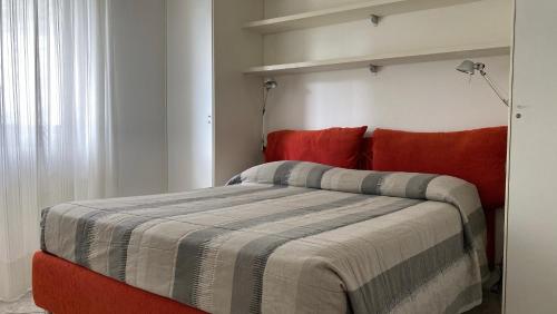 a bedroom with a large bed with red pillows at Appartamenti Nataly in Nago-Torbole