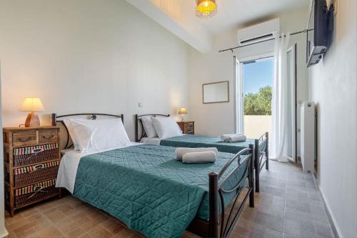 een slaapkamer met een bed met een groen dekbed bij Dimitra's South House in Neochorákion