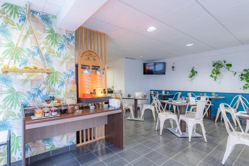 une salle à manger avec des tables et des chaises blanches dans l'établissement Appart'City Confort Pau Centre, à Pau