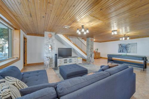 a living room with a blue couch and a piano at Lakefront Eufaula Escape with Dock and Private Beach! in Eufaula