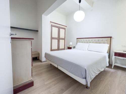 a bedroom with a large white bed and a window at Luxury Apartment next to the Francescana in Modena