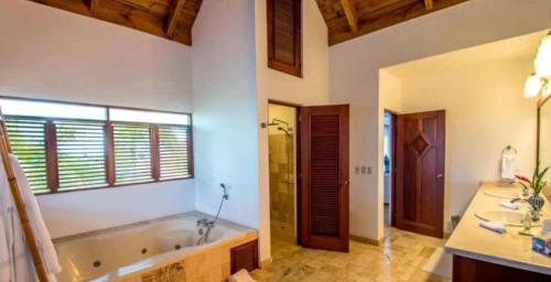 baño con bañera grande y 2 lavabos en Sunny Vacation Villa No 75, en San Rafael del Yuma