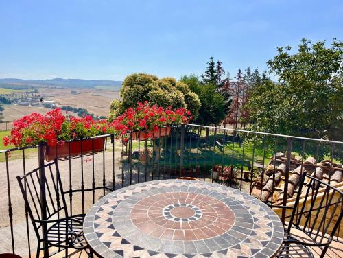 a patio with a table and chairs and flowers at Poggiosalto in Toscana in Pienza