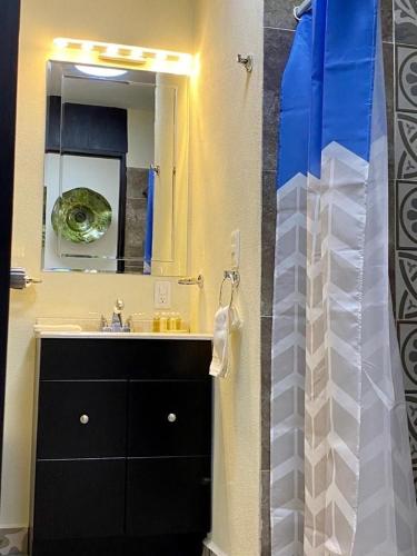 a bathroom with a sink and a large mirror at SM Apartments in San José del Cabo