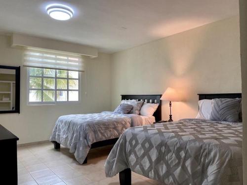 um quarto com 2 camas e uma janela em Zona Hotelera San José del Cabo em San José del Cabo