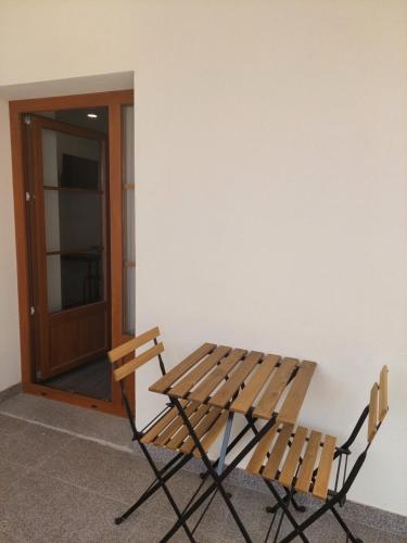 a wooden table and two chairs next to a door at OH Studios Lousã in Lousã