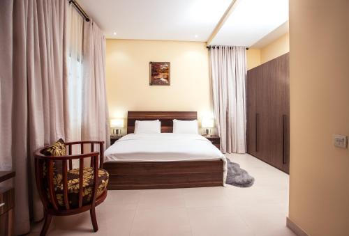 a bedroom with a bed and a chair at Rushmore - Premier 1 Room in Lagos