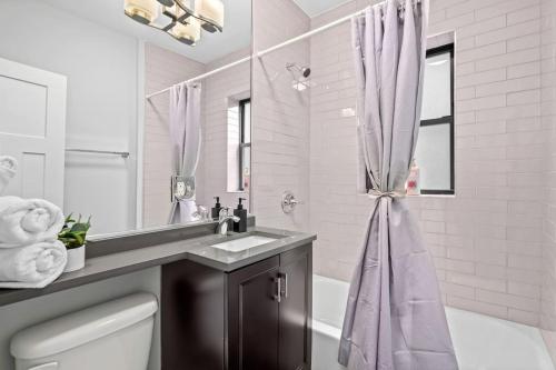 ein Bad mit einem Waschbecken und einem Duschvorhang in der Unterkunft Chic & Fully Furnished Studio Apt with Laundry - Brompton 61-66 rep in Chicago