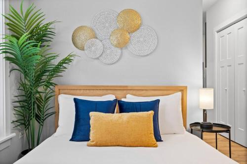 ein Schlafzimmer mit einem Bett mit blauen und goldenen Kissen in der Unterkunft Chic & Fully Furnished Studio Apt with Laundry - Brompton 61-66 rep in Chicago