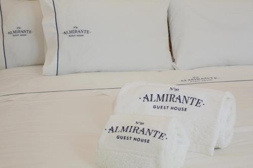due asciugamani bianchi su un letto in una vetrina di Nº 91 - Almirante Guest House a Porto