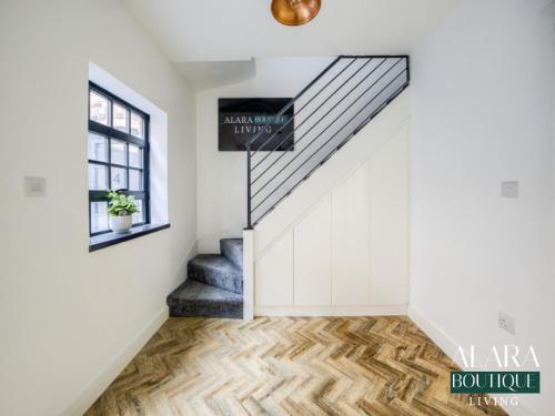 a staircase in a home with white walls and wood floors at 3 Floor Townhouse Luxury Living Alara Boutique in Birmingham