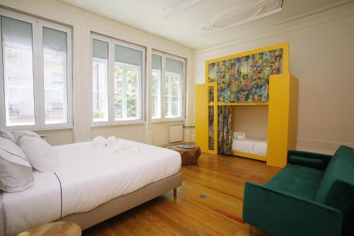 una camera con letto, divano e finestre di Nº 91 - Almirante Guest House a Porto