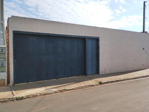 - une grande porte de garage bleue sur le côté du bâtiment dans l'établissement Barretos casa pra festa do peão, à Barretos