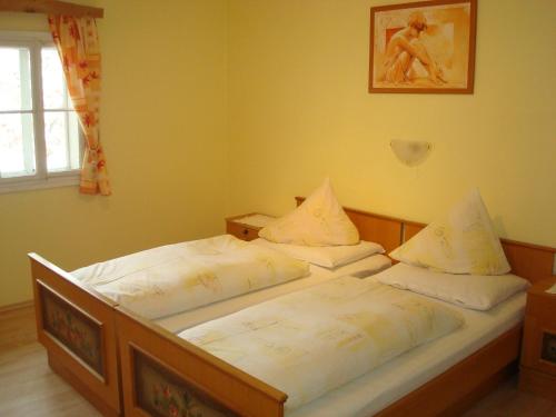 two twin beds in a small room with a window at Gästehaus-Pension Bendler in Kirchdorf in Tirol