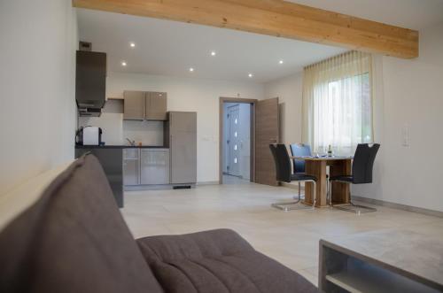 a living room with a table and chairs and a kitchen at Familienhotel Steindl in Millstatt