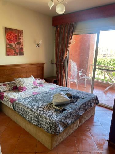 a bedroom with a bed and a balcony at Gulf Porto Marina Call First in El Alamein