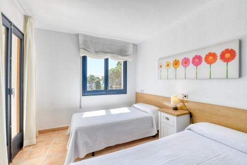 カレリャ・デ・パラフルジェリにあるSecond line in Calella with seaviewsのベッドルーム1室(ベッド2台、窓付)