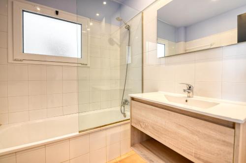 ein Bad mit einem Waschbecken, einer Badewanne und einem Fenster in der Unterkunft Second line in Calella with seaviews in Calella de Palafrugell