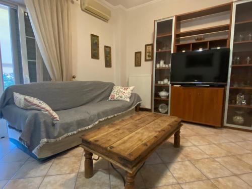 ein Wohnzimmer mit einem Sofa und einem Couchtisch in der Unterkunft COZY & QUIET CITY APARTMENT in Tríkala