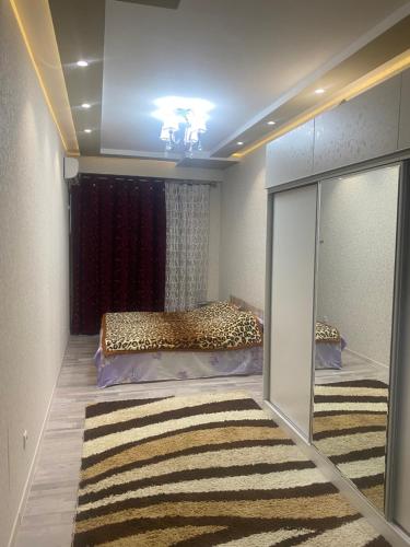 sypialnia z łóżkiem i lustrem w obiekcie Park Istiklol w mieście Duszanbe