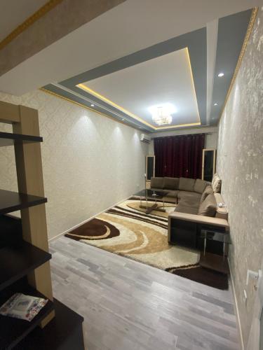een woonkamer met een bank en een tafel bij Park Istiklol in Doesjanbe