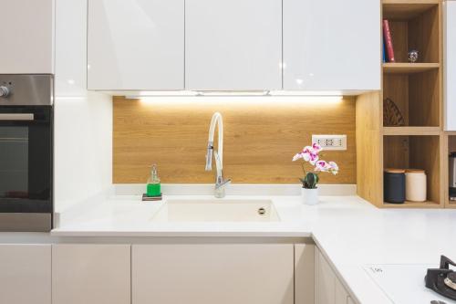 a kitchen with a white sink and white cabinets at Cozy flat with terrace at Trastevere train station in Rome