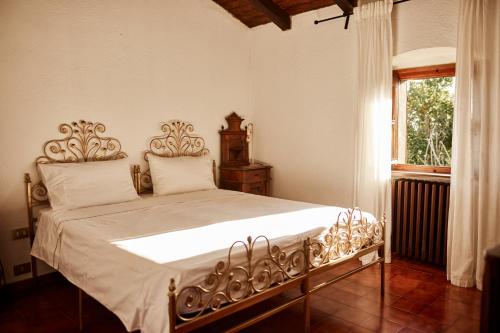 a bedroom with a bed with white sheets and a window at Il Torrione del Trebbia in Bobbio