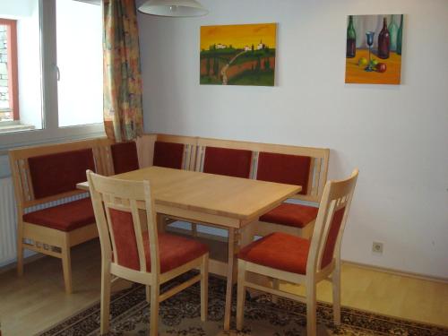 a dining room table with chairs and a wooden table at Gästehaus-Pension Bendler in Kirchdorf in Tirol