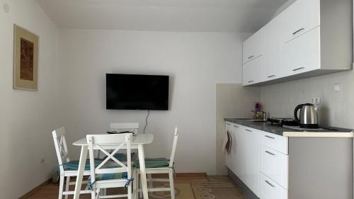 een keuken met witte kasten en een tafel en stoelen bij B&B Hills Bihać in Bihać