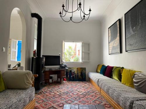 a living room with two couches and a television at Kasbah’s road Art house in Tangier