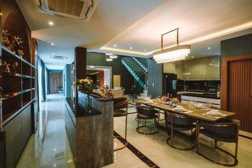a kitchen and dining room with a table and chairs at Minho Villa Luxury Pattaya in Nong Prue