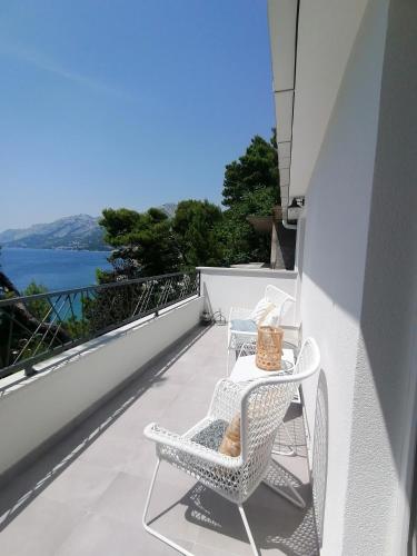 a balcony with two chairs and a table with a view at Apartmani Mares - 20 m from the beach in Brela