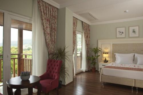 GökovaにあるPadok Premium Hotel & Stablesのベッドルーム1室(ベッド1台、テーブル、椅子付)