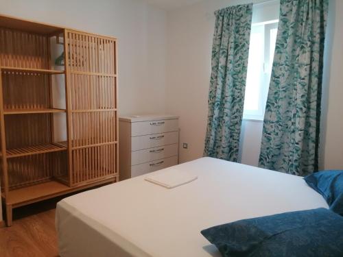 a bedroom with a bed and a book shelf at Apartmani Mares - 20 m from the beach in Brela