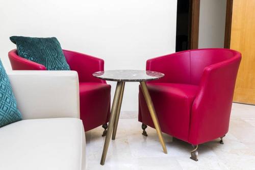2 Stühle und ein Tisch in einem Zimmer in der Unterkunft Hôtel Bachou in Dakar